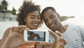 A young couple taking a selfie with a smartphone camera