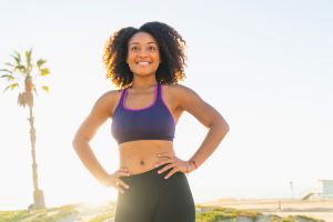 Portrait of mid adult woman, hands on hips, smiling, outdoors