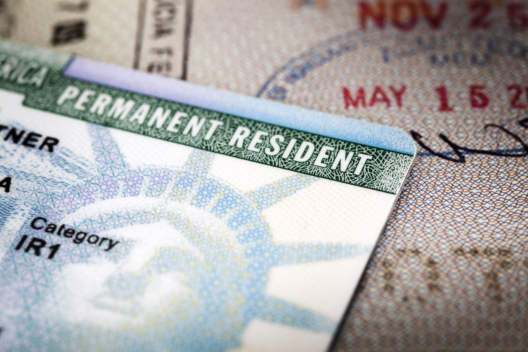 A Green Card lying on an open passport, close-up, full frame