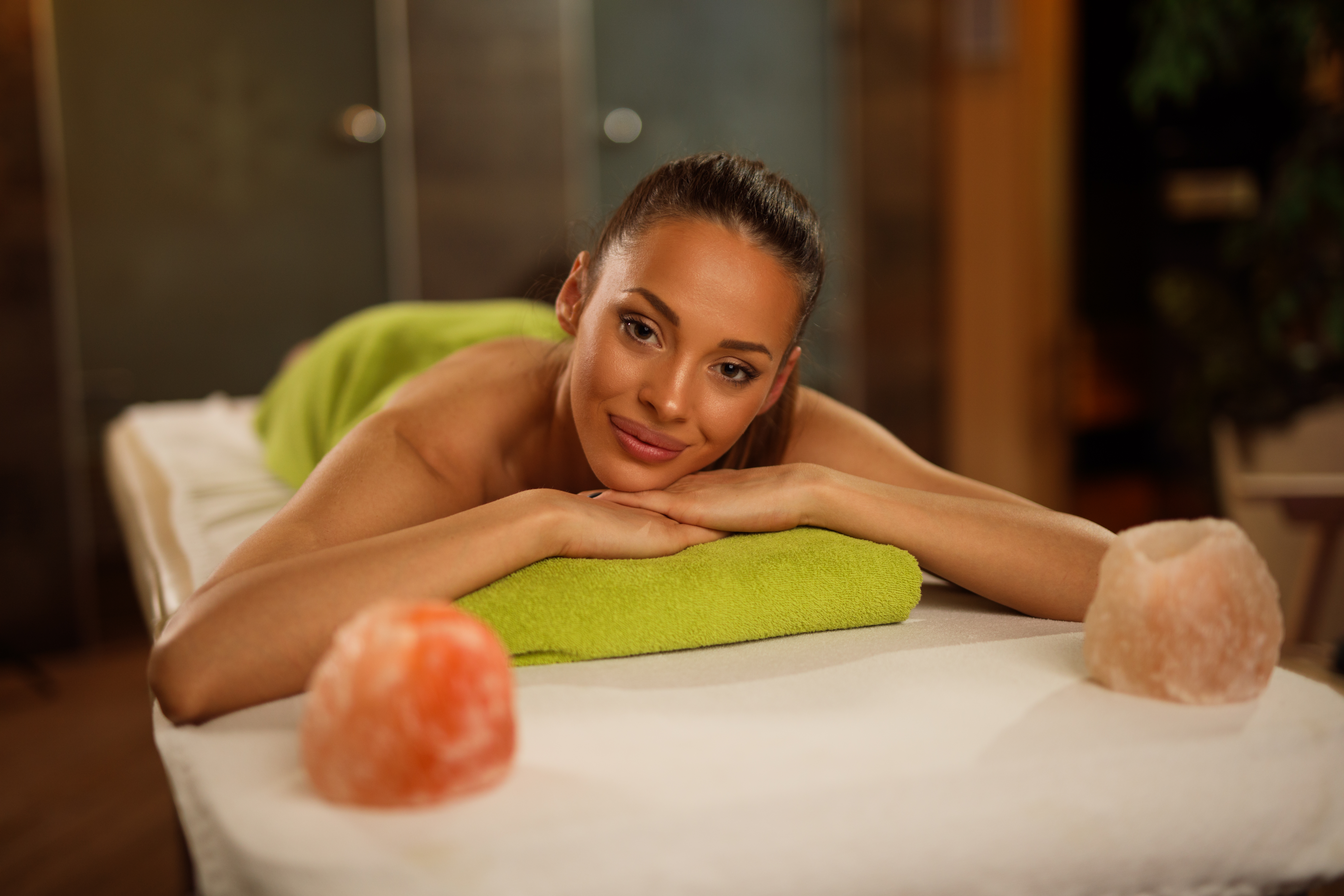 Young woman relaxing on massage table at health spa