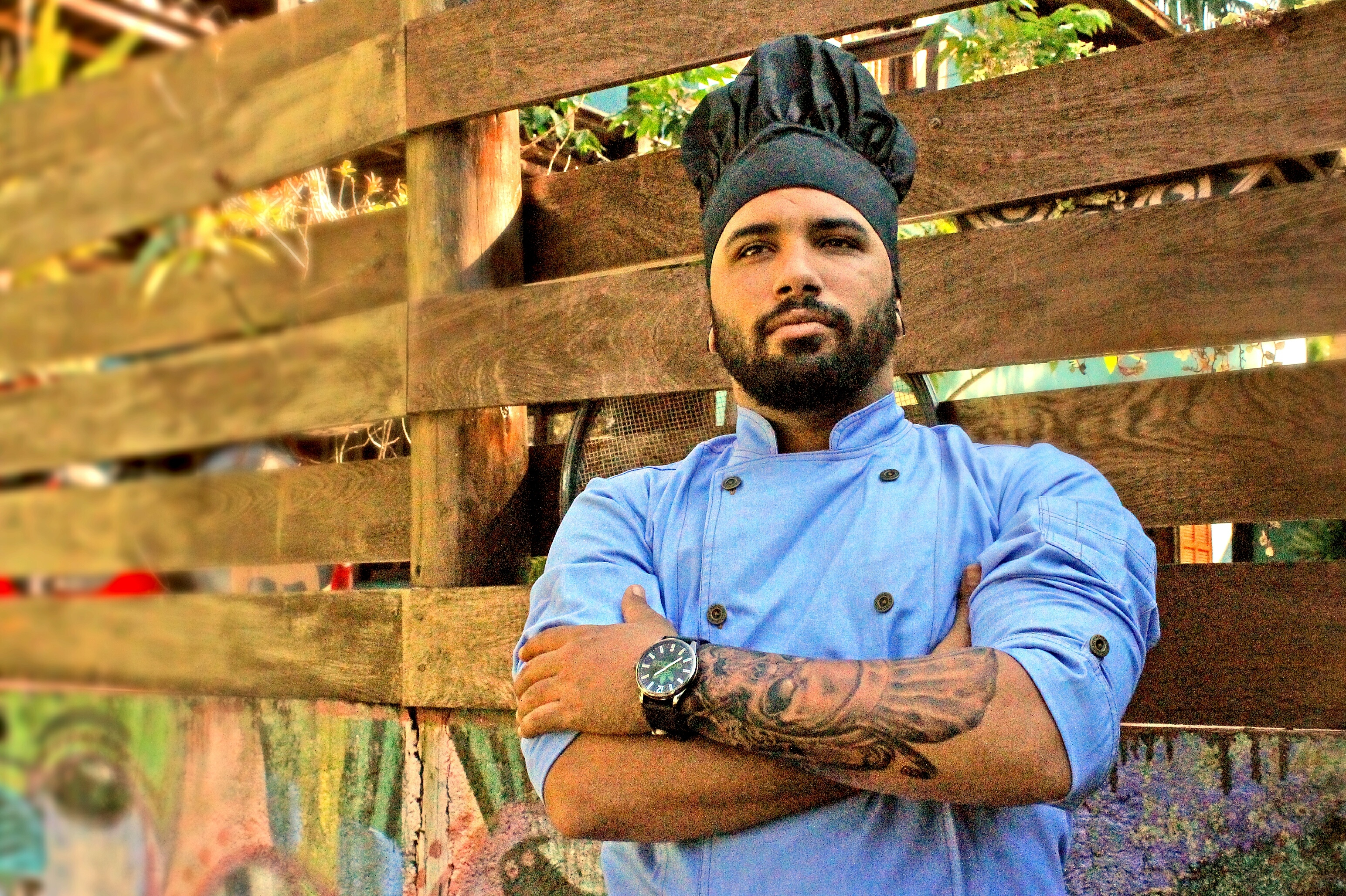 Chef With Arms Crossed Standing By Wooden Fence