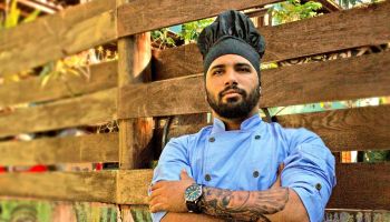 Chef With Arms Crossed Standing By Wooden Fence