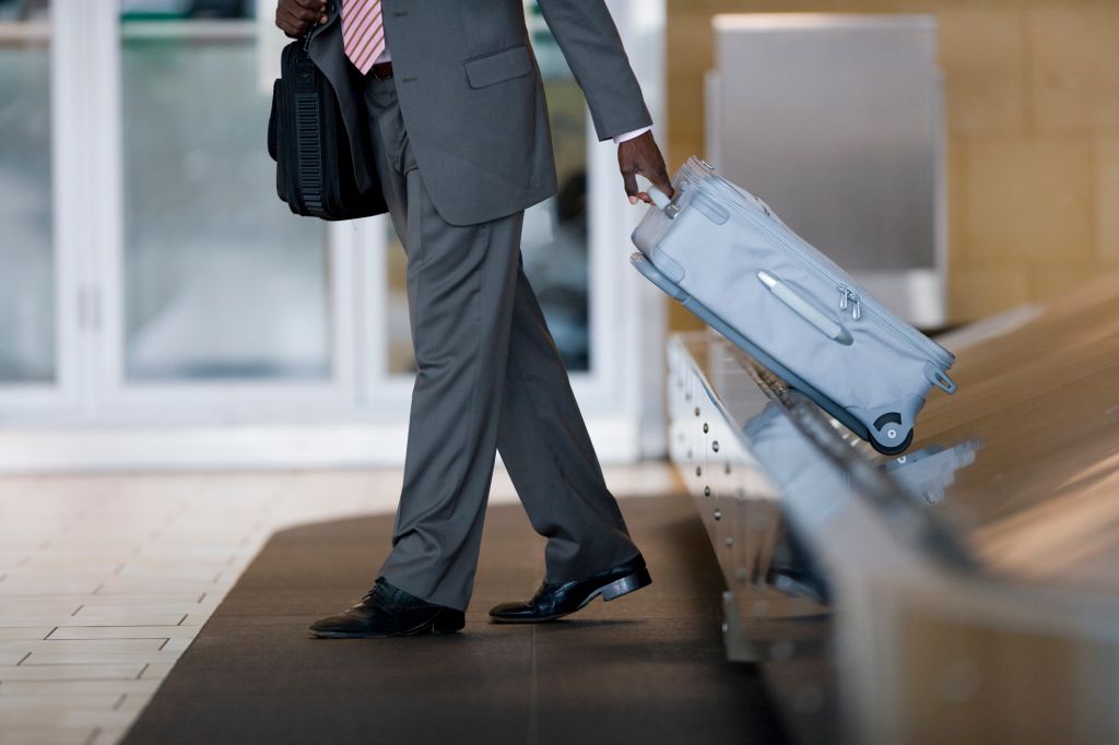 Businessman removing suitcase from luggage carousel in baggage claim