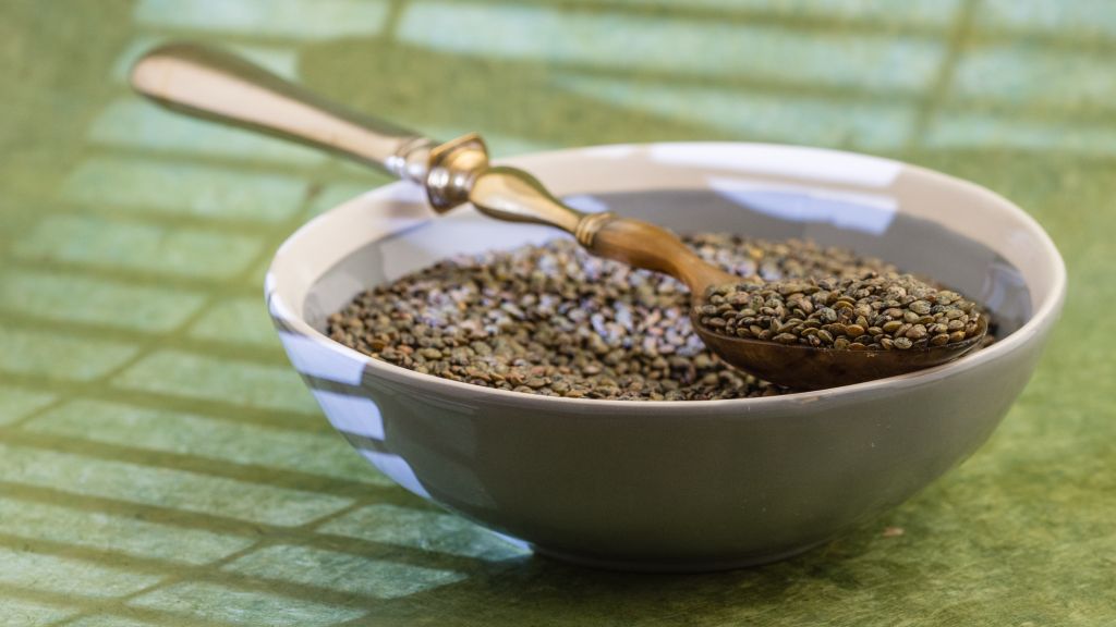 Bowl and spoon of green lentils.