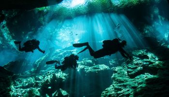 Diver enters the cavern system at Chac Mool cenote in the Riviera Maya area of Mexicos Yucatan Peninsula.