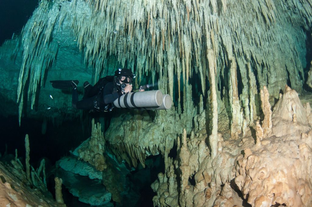 Diver using side mount gear in cave in Mexico.