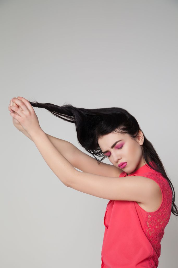 Model with pink makeup pulling hair
