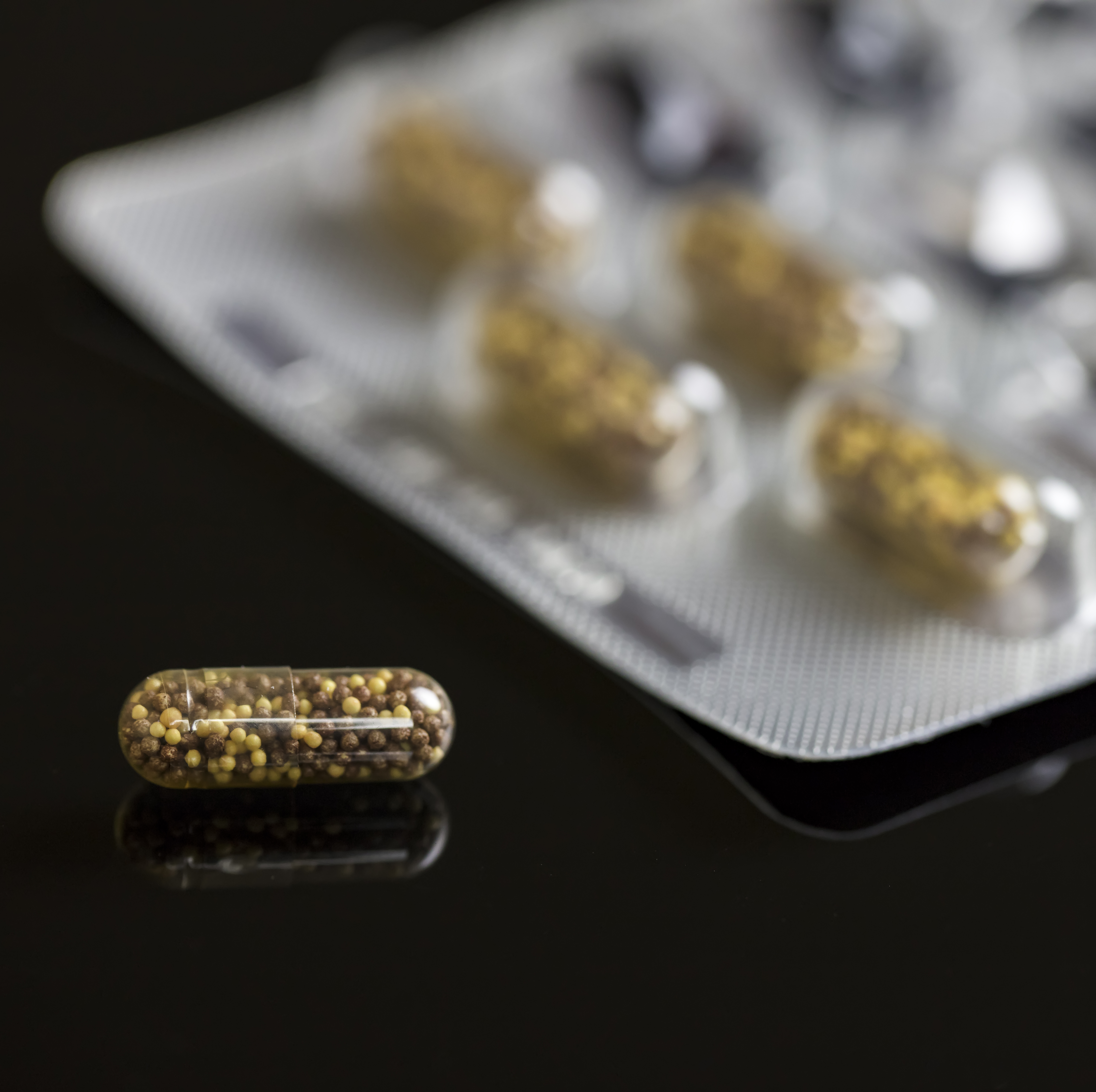 Transparent Capsule On black background. Medical concept