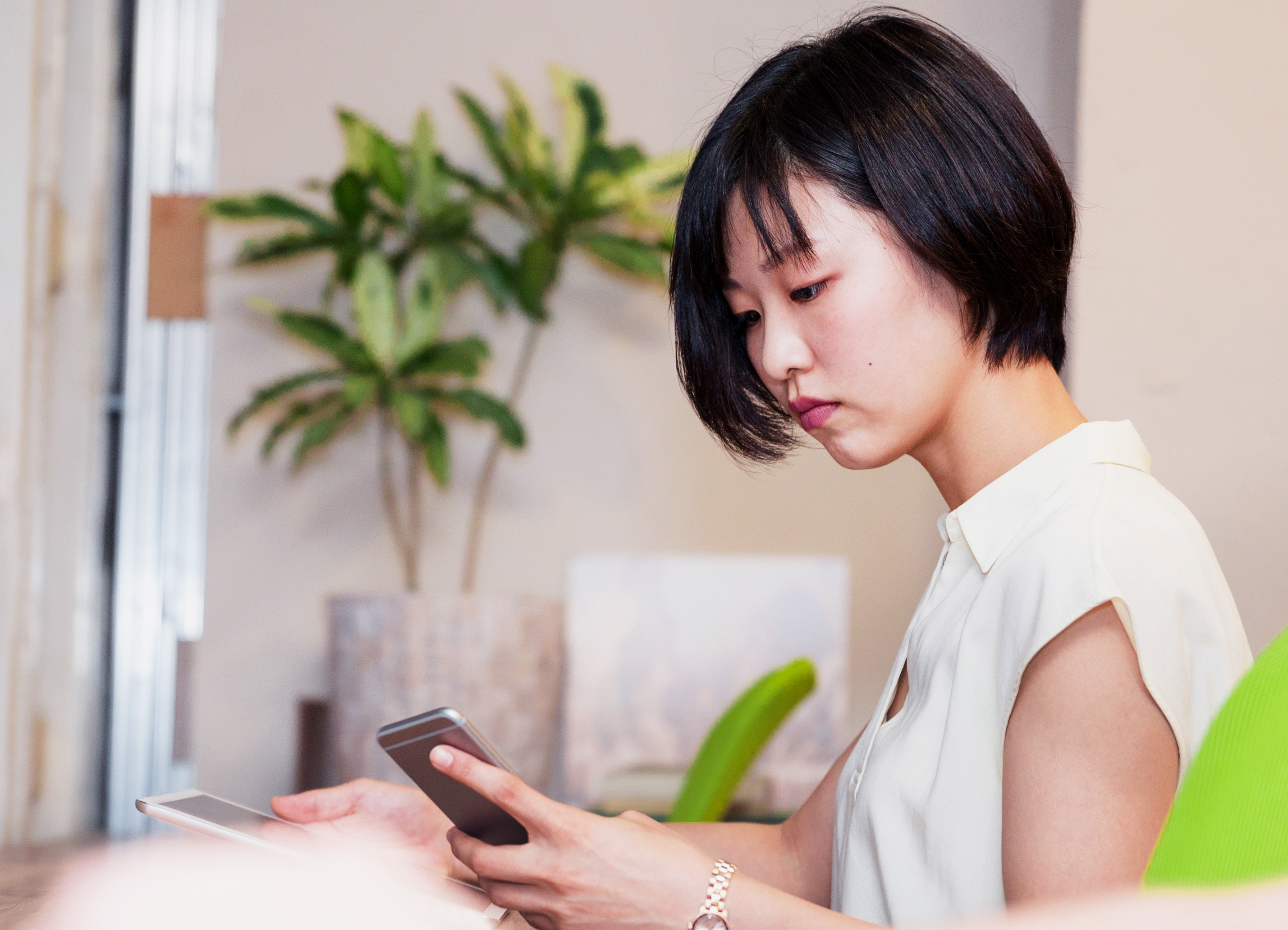 Korean businesswoman using a smartphone while also using a digital tablet