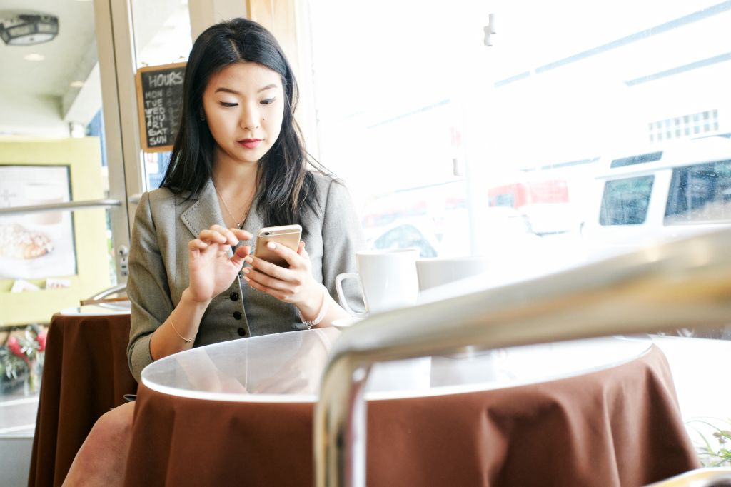 Asian businesswoman texting on cell phone