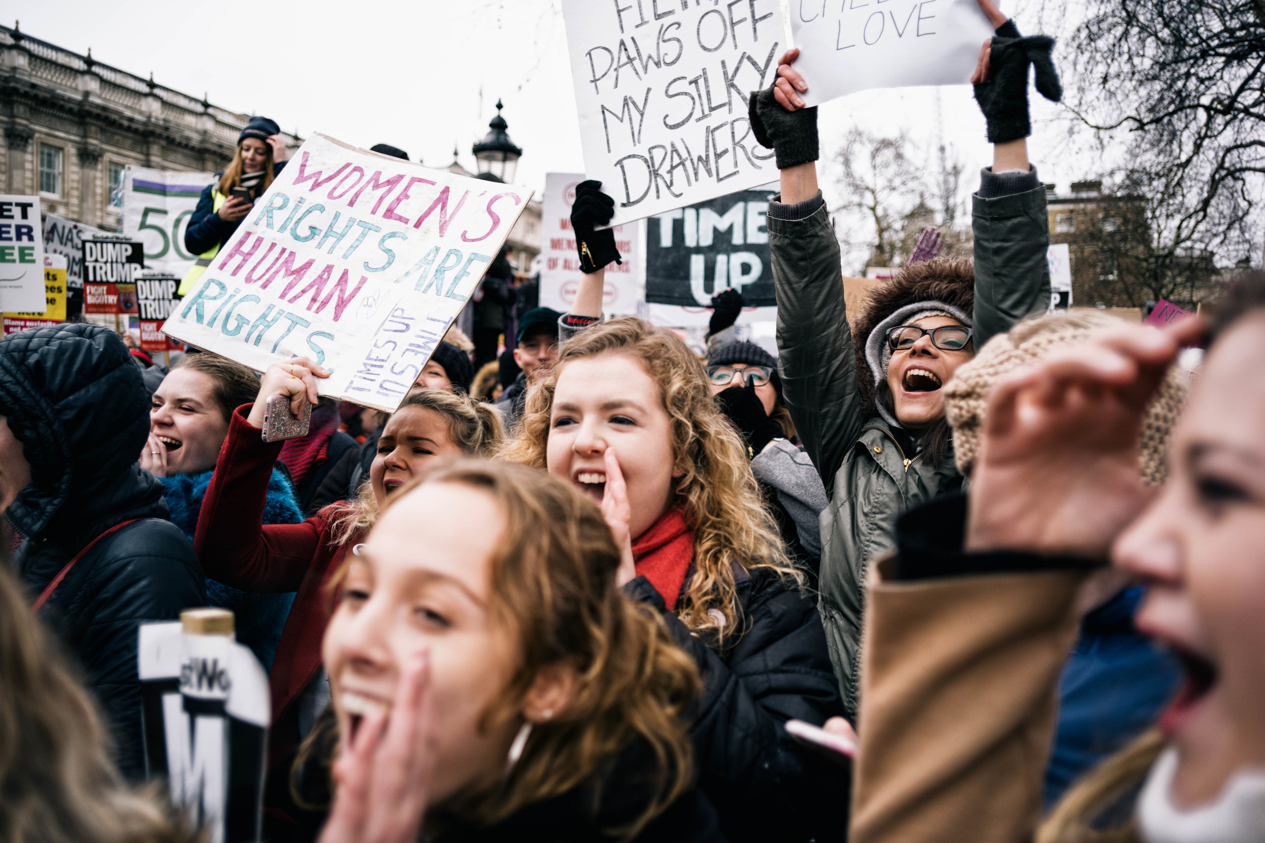 Women seen shouting slogans while holding placards and...