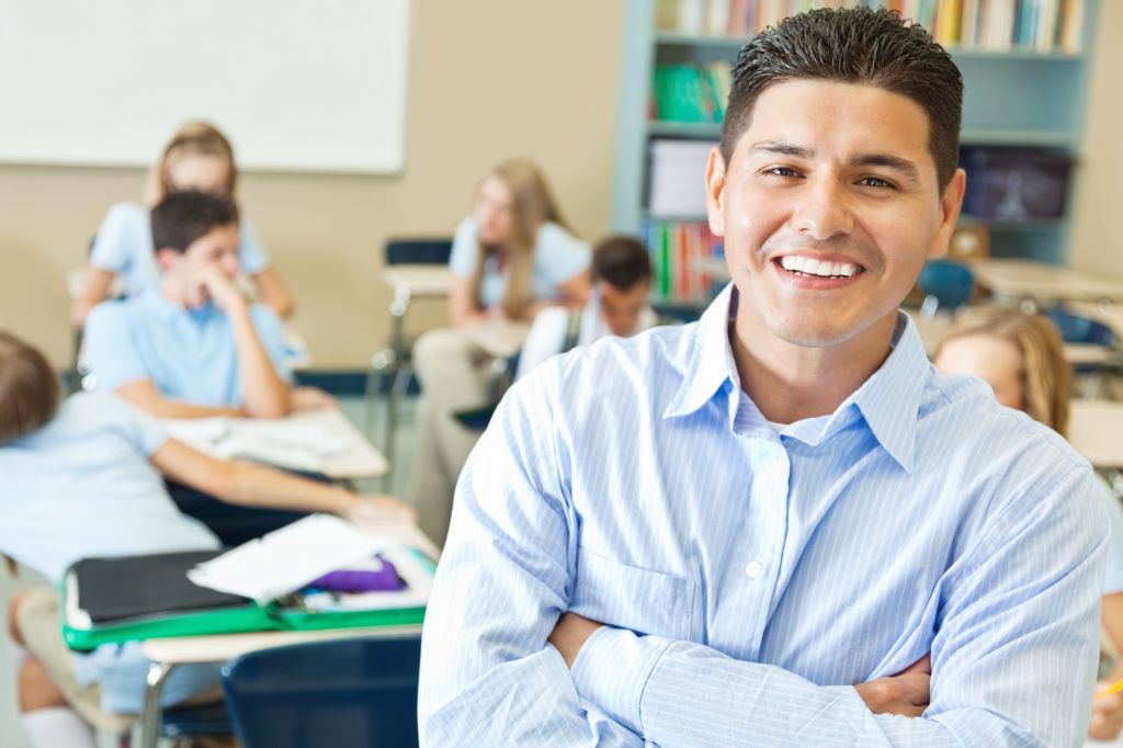 Confident Hispanic private school teacher in classroom