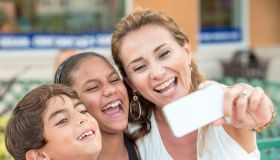 Mature woman posing with her children taking a selfie