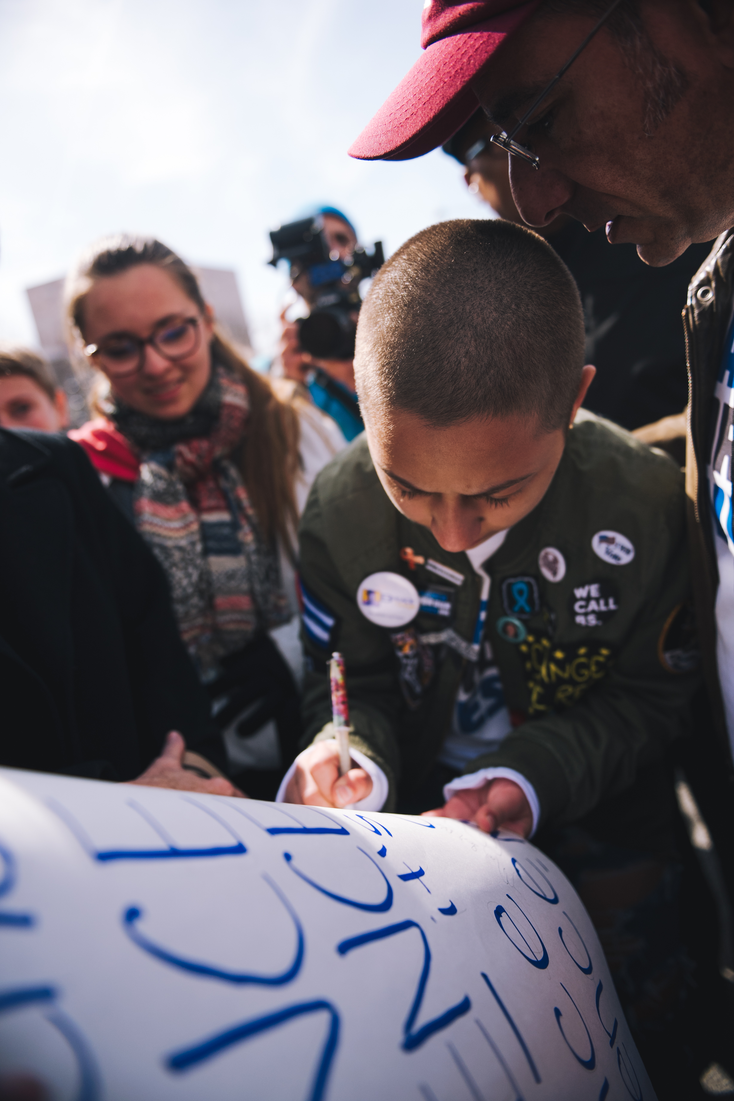 Emma Gonzalez signs a poster with Martin Luther King Jr...