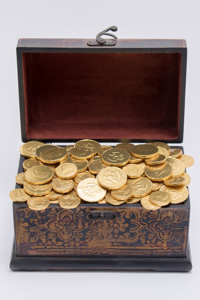 Gold Coins In Treasure Chest Against White Background
