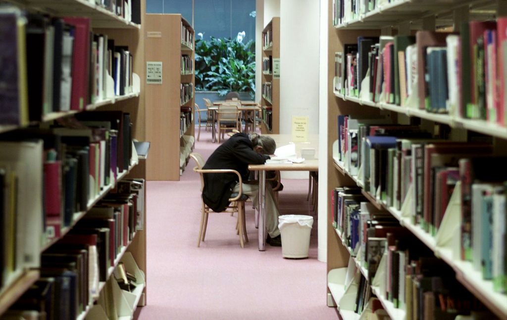 A man sleeps at a table in the Mitchell Library, 18 July 2000. SMH Picture by A