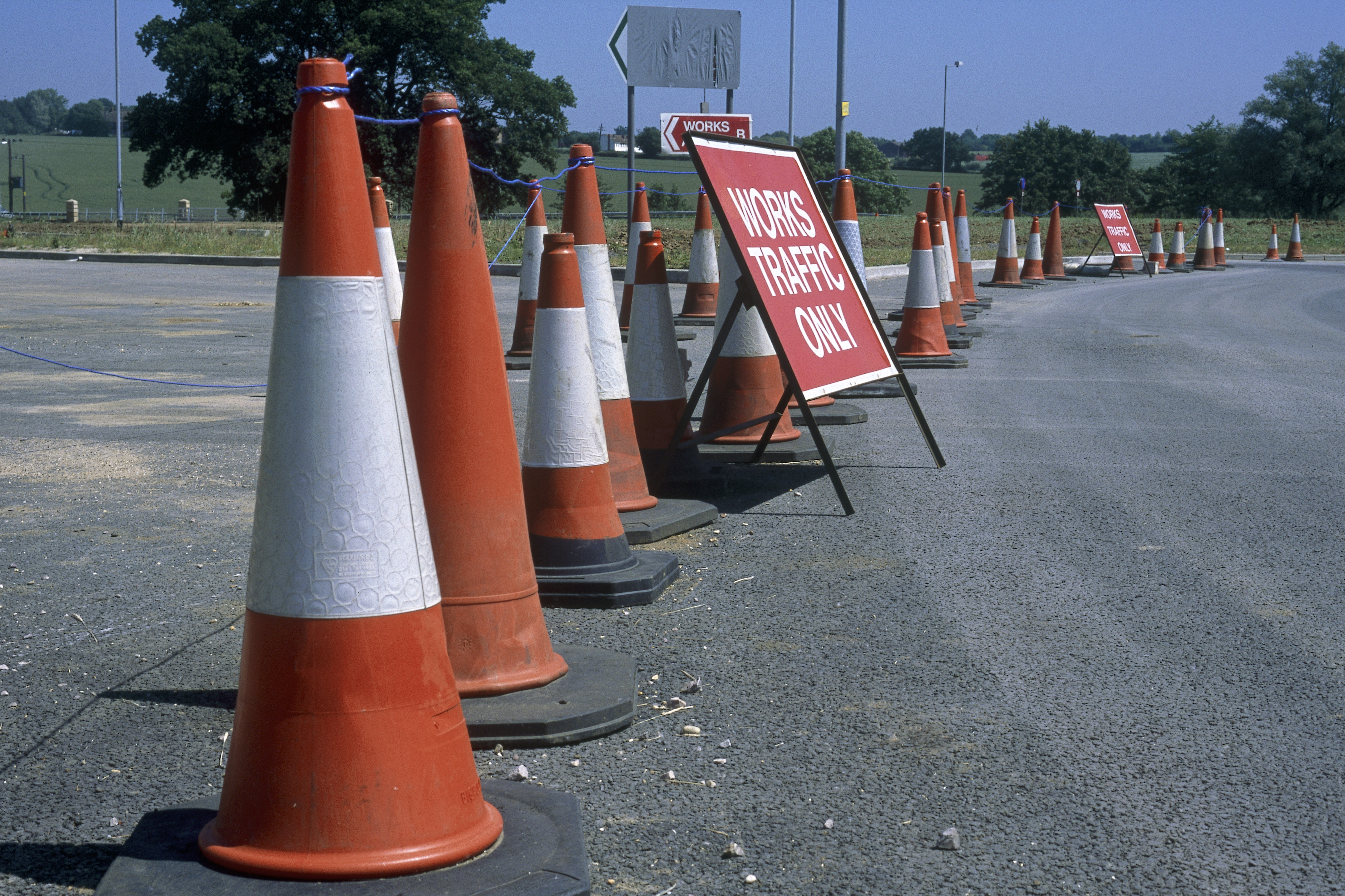 Traffic cones separating construction site and works access from public highway during construction of Great Leighs bypass. Essex, United Kingdom.