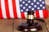 Close-Up Of Gavel With Hammer On Table Against American Flag