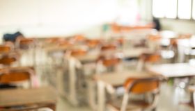 Defocused Image Of Blank Chairs And Tables At Classroom