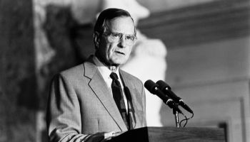 George H.W. Bush talking over microphone
