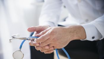 Mixed race doctor's hands holding stethoscope