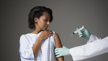 Mid adult woman receiving injection