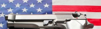 Stainless steel 9 mm caliber handgun laying on an American flag background - part of a series