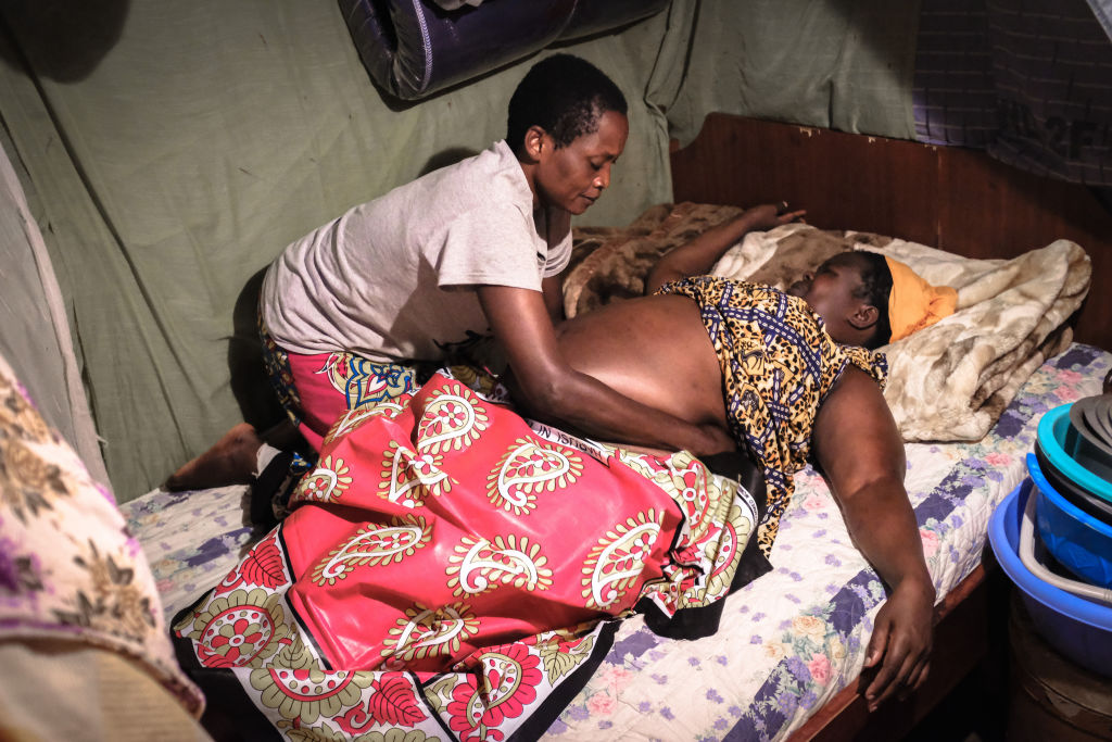 A midwife is seen massaging a pregnant lady in preparation...