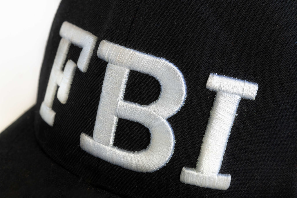 Close up of the FBI logo on a black cap. The text stands for...