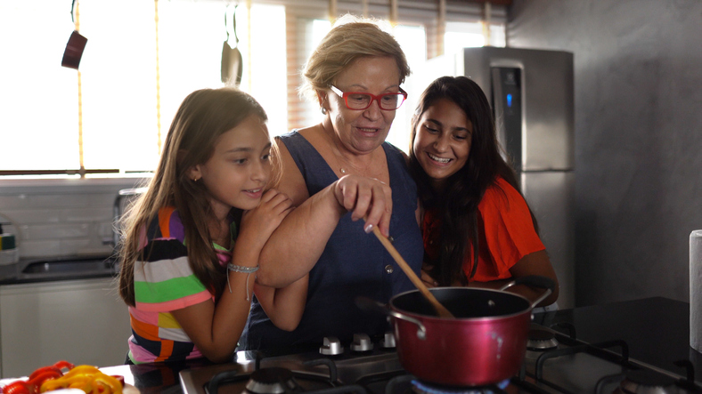 Grandmother cooking with granddaughters at home