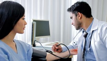 Healthcare, hospital and medicine concept. Doctor measuring blood pressure from patient