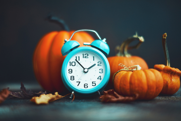 Time for Fall. Teal alarm clock with leaves and Pumpkins