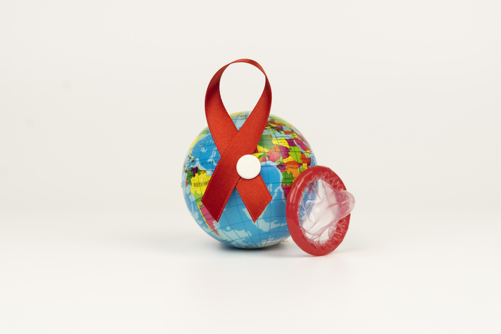 World protection from AIDS. Worl map, condom and Awareness Ribbon on white background.