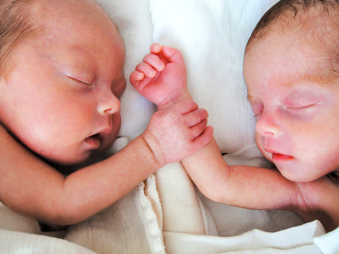 Newborn Premature Twins holding hands