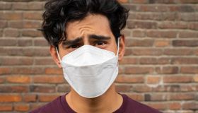 Young Latino man wearing a face mask and looking very confused and frustrated at the camera