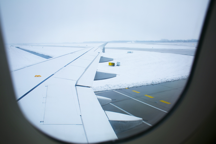 Snowy runway seen through airplane window