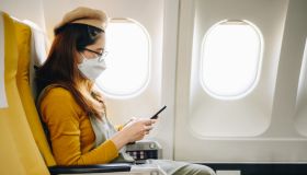 Asian passenger wearing face mask while seating on plane. New normal lifestyle of people after covid-19 pandemic.