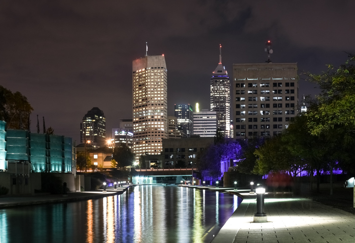 Indianapolis skyline illuminated at night and reflected on White river canal in Indiana, USA