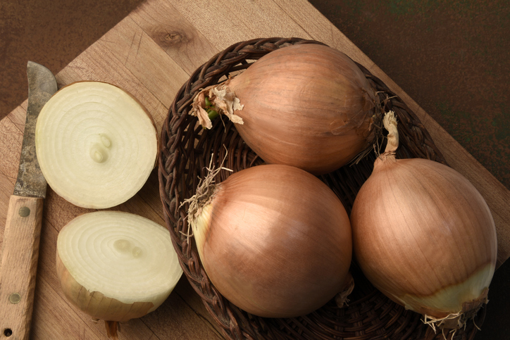 whole onions on wood board