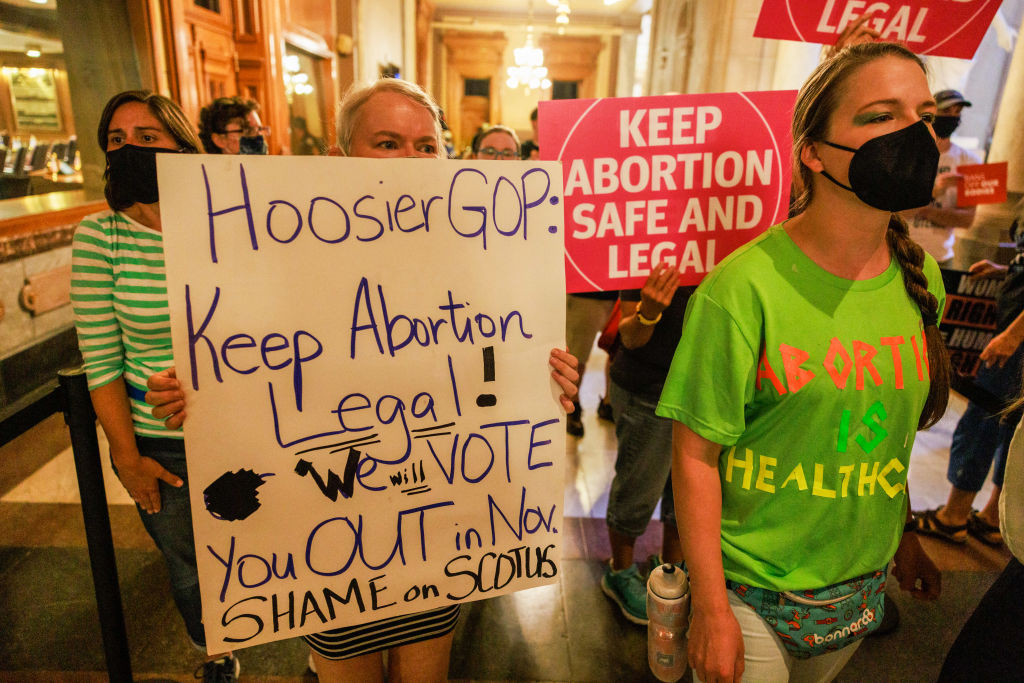 An abortion rights activist holds a sign reading, We will...
