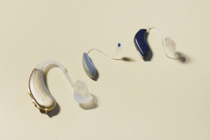 High angle view of various hearing aids on yellow table