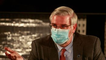 Indiana Governor Eric Holcomb wearing a face mask speaks...