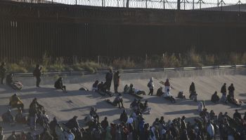 Migrants wait on the Mexican bank of the Rio Grande in Ciudad Juarez