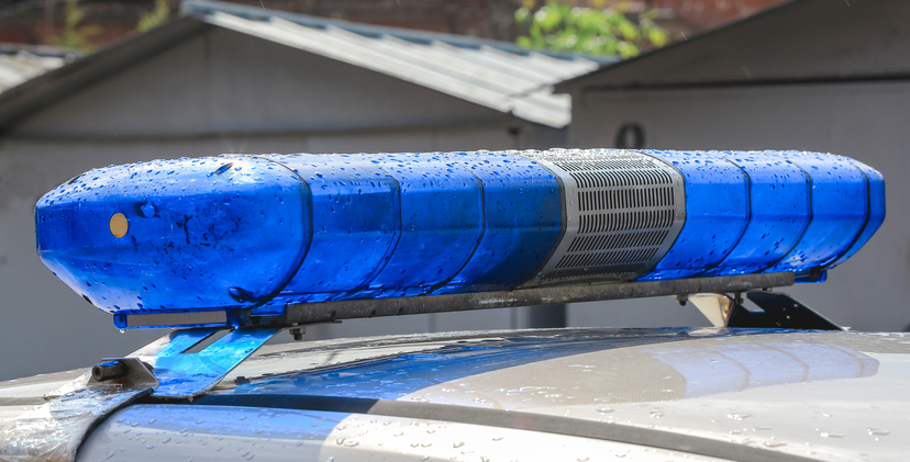 Close-up of blue lights on the roof of a police car. Flashing beacons of a police car. Selective focus. Police service car siren on the roof. Arrest of the criminal.