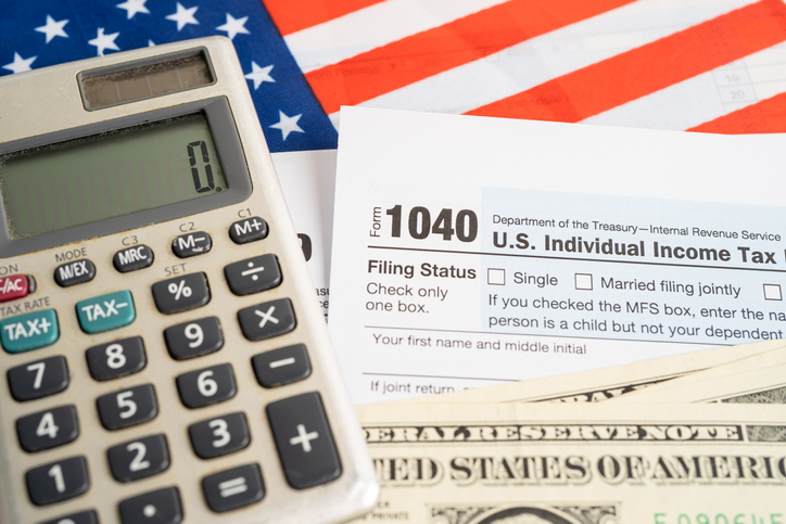 Tax Return form 1040 with USA America flag and dollar banknote, U.S. Individual Income.