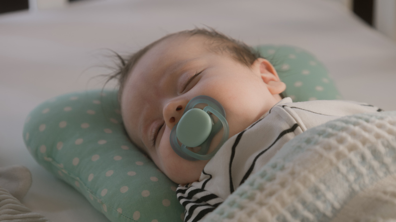 Father puts newborn baby in white cradle