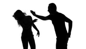 Silhouette of a man slapping his woman