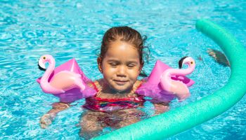 Little girl enjoying herself in the swimming pool with floats,Madrid,Spain