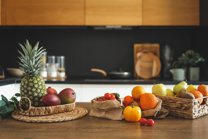 Close-up of vegetables and fruits on a wooden table in the background of the kitchen. Balanced diet, cooking, nutrition concept
