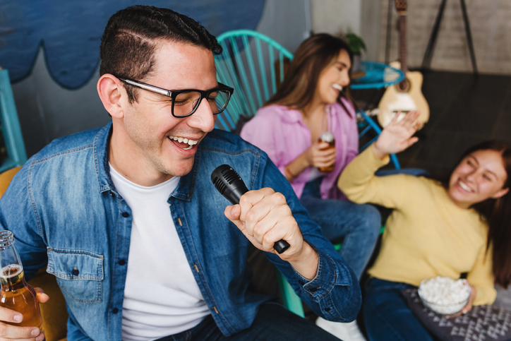 hispanic friends singing karaoke at home in Mexico Latin America